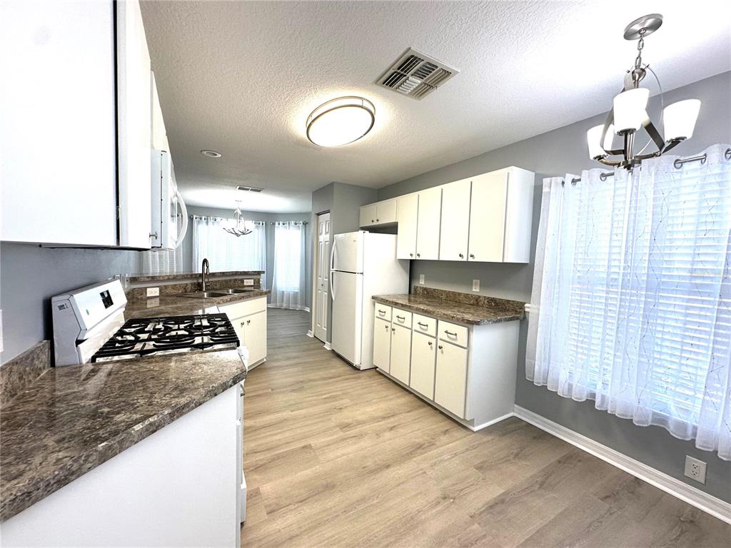 9706 Southwest 92nd Place Road Ocala, FL 34481 - Photo 8 of 82 a kitchen with granite countertop a stove a sink and a refrigerator