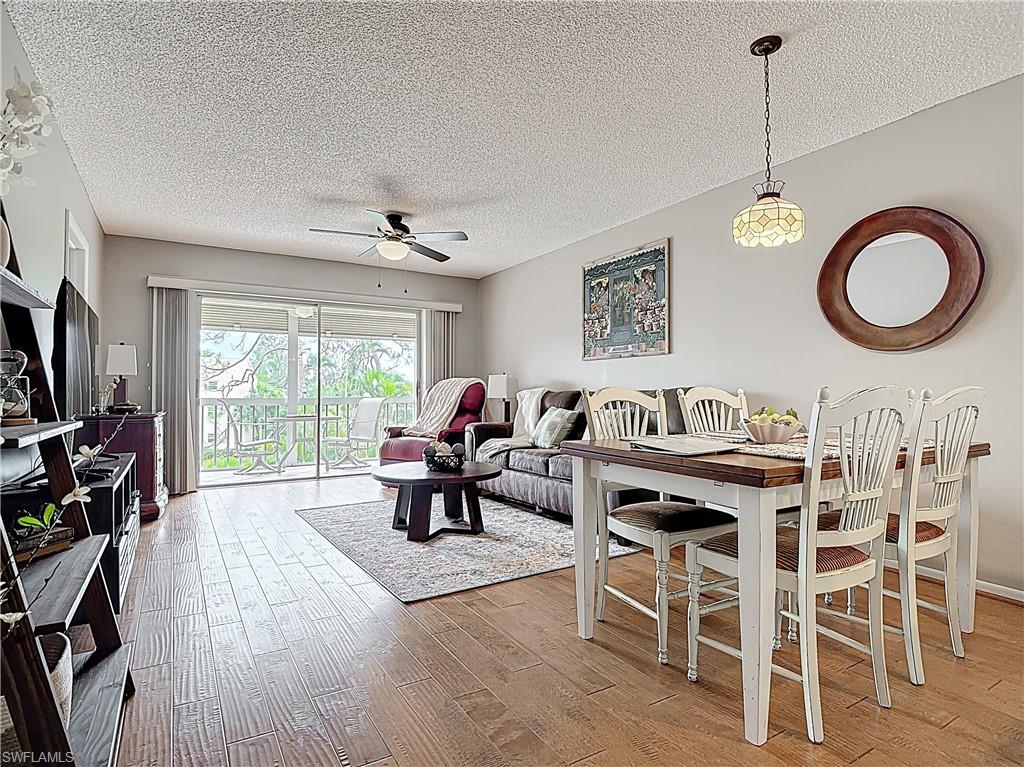 150 Turtle Lake Court, Unit 309 Naples, FL 34105 - Photo 15 of 42 Living room featuring light wood-type flooring, ceiling fan, and a textured ceiling