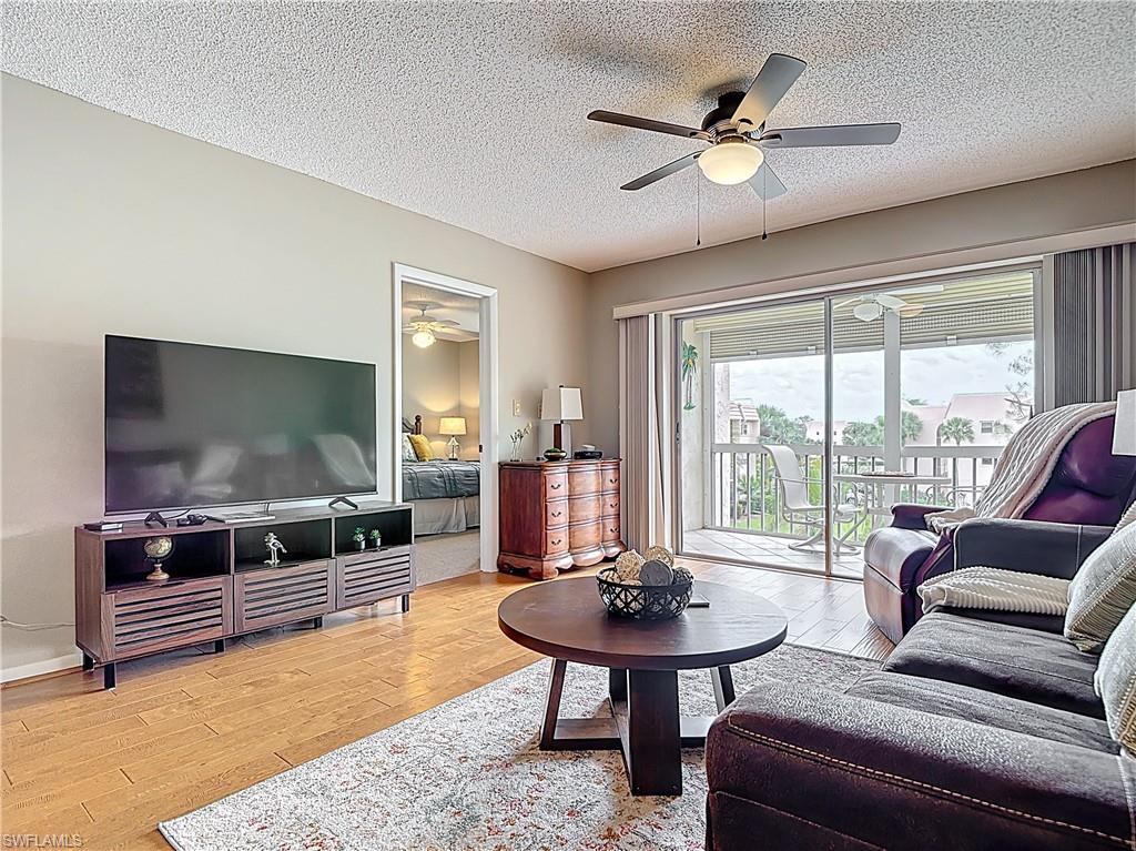150 Turtle Lake Court, Unit 309 Naples, FL 34105 - Photo 16 of 42 Living area with ceiling fan, wood finished floors, and a textured ceiling