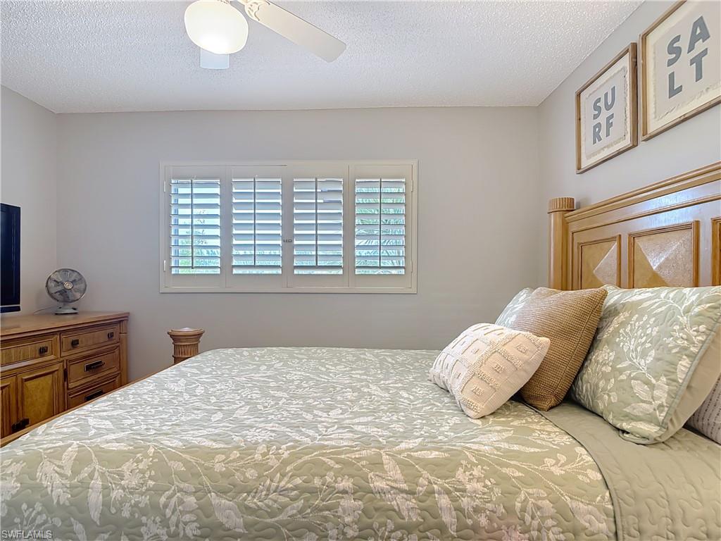 150 Turtle Lake Court, Unit 309 Naples, FL 34105 - Photo 21 of 42 Bedroom featuring a textured ceiling and a ceiling fan