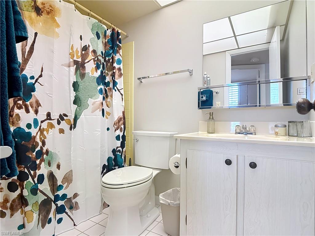 150 Turtle Lake Court, Unit 309 Naples, FL 34105 - Photo 22 of 42 Full bath with tile patterned floors, toilet, vanity, and a shower with shower curtain