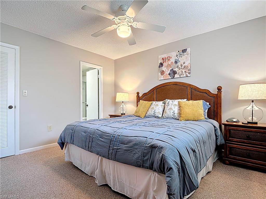 150 Turtle Lake Court, Unit 309 Naples, FL 34105 - Photo 24 of 42 Carpeted bedroom with ceiling fan, a textured ceiling, and baseboards