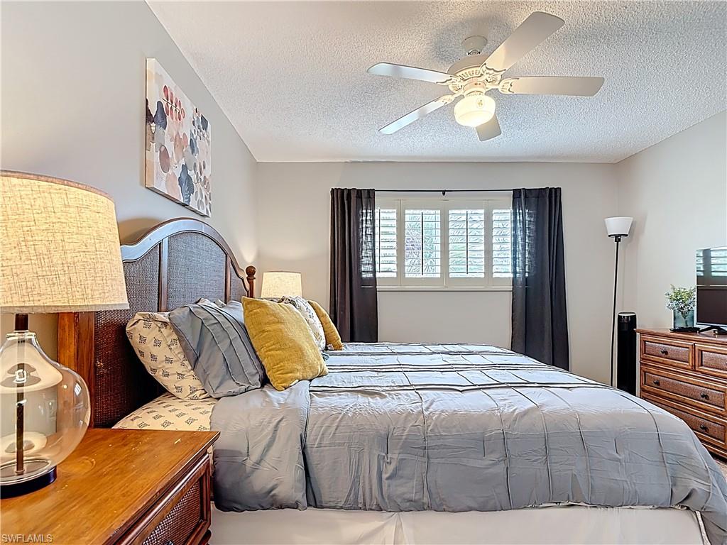 150 Turtle Lake Court, Unit 309 Naples, FL 34105 - Photo 26 of 42 Bedroom featuring a textured ceiling and ceiling fan