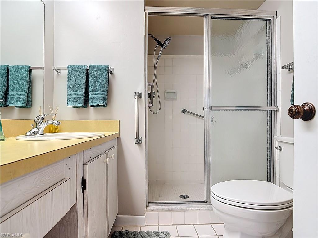 150 Turtle Lake Court, Unit 309 Naples, FL 34105 - Photo 27 of 42 Full bathroom with toilet, a stall shower, tile patterned flooring, and vanity