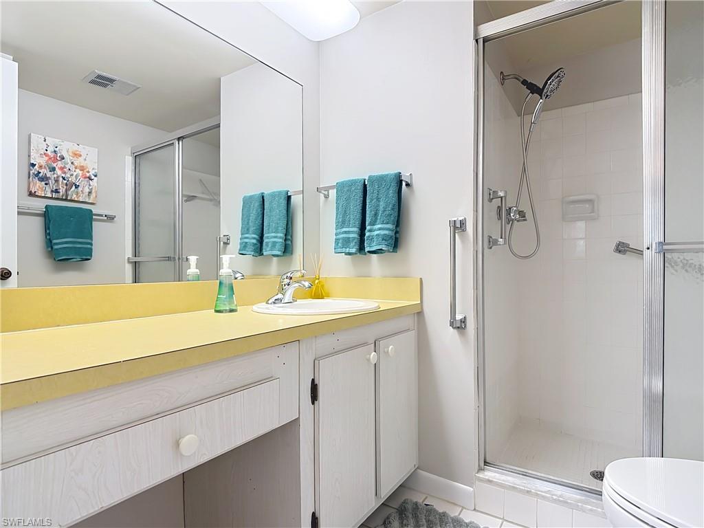 150 Turtle Lake Court, Unit 309 Naples, FL 34105 - Photo 28 of 42 Bathroom with a shower stall, vanity, toilet, and tile patterned floors