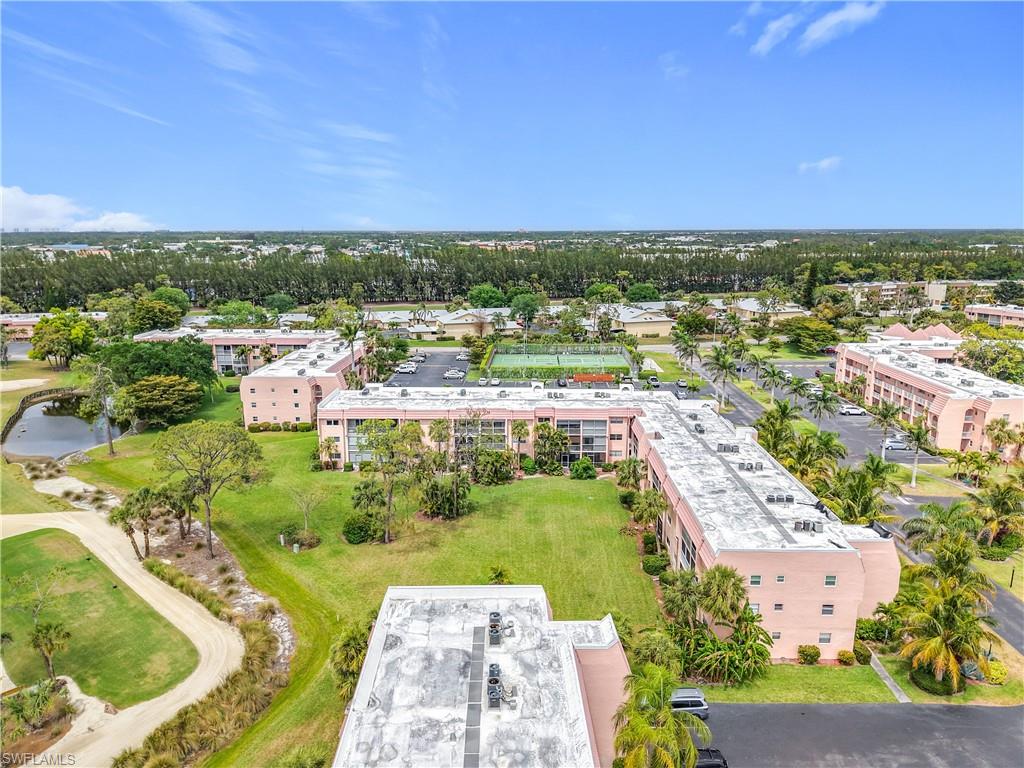 150 Turtle Lake Court, Unit 309 Naples, FL 34105 - Photo 37 of 42 Bird's eye view of apartment complex, a tree filled landscape, and a nearby body of water