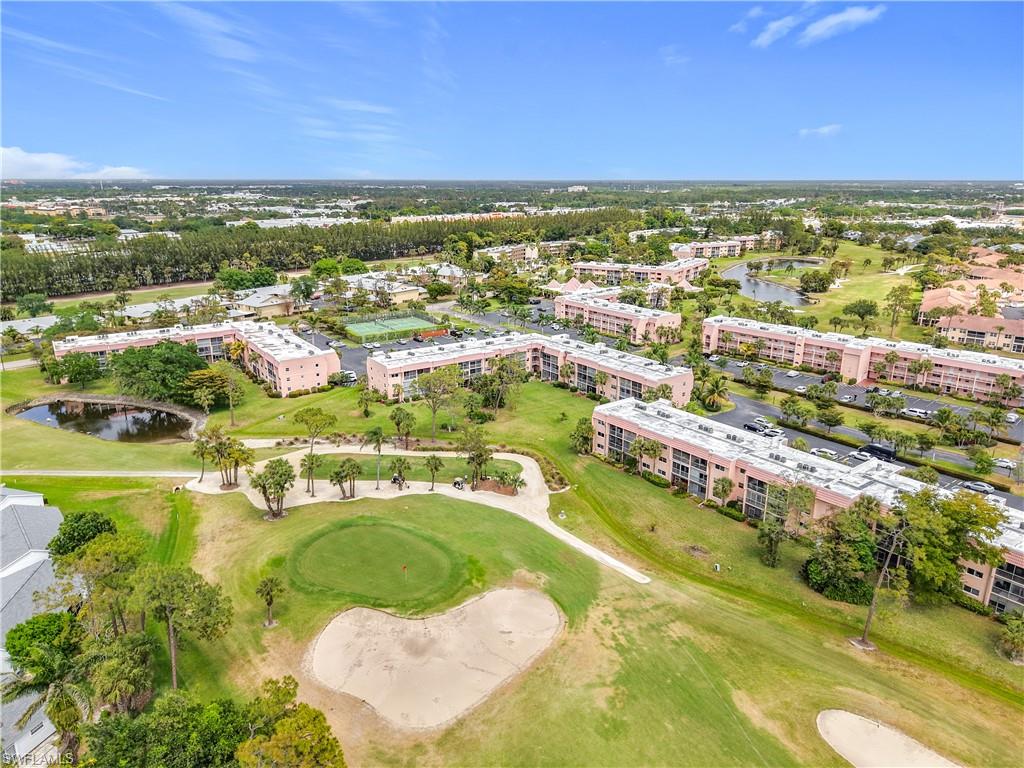 150 Turtle Lake Court, Unit 309 Naples, FL 34105 - Photo 41 of 42 Drone / aerial view of apartment complex, a golf course, and a large body of water