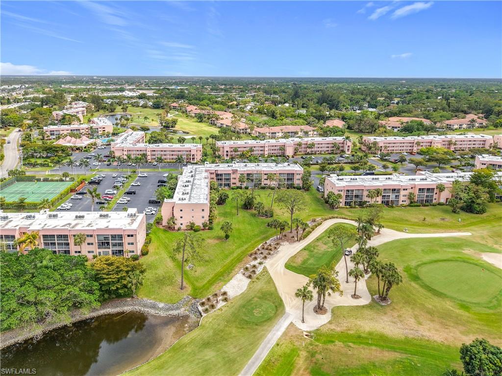 150 Turtle Lake Court, Unit 309 Naples, FL 34105 - Photo 42 of 42 Aerial view of apartment complex, a golf club, and a large body of water