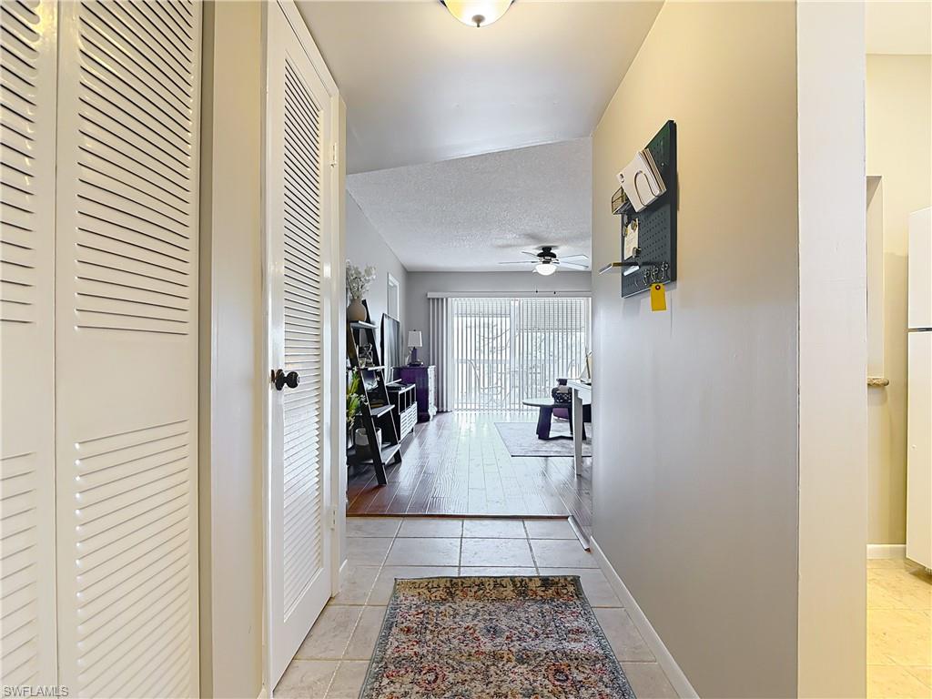150 Turtle Lake Court, Unit 309 Naples, FL 34105 - Photo 10 of 42 Hallway with light tile patterned floors, baseboards, and a textured ceiling