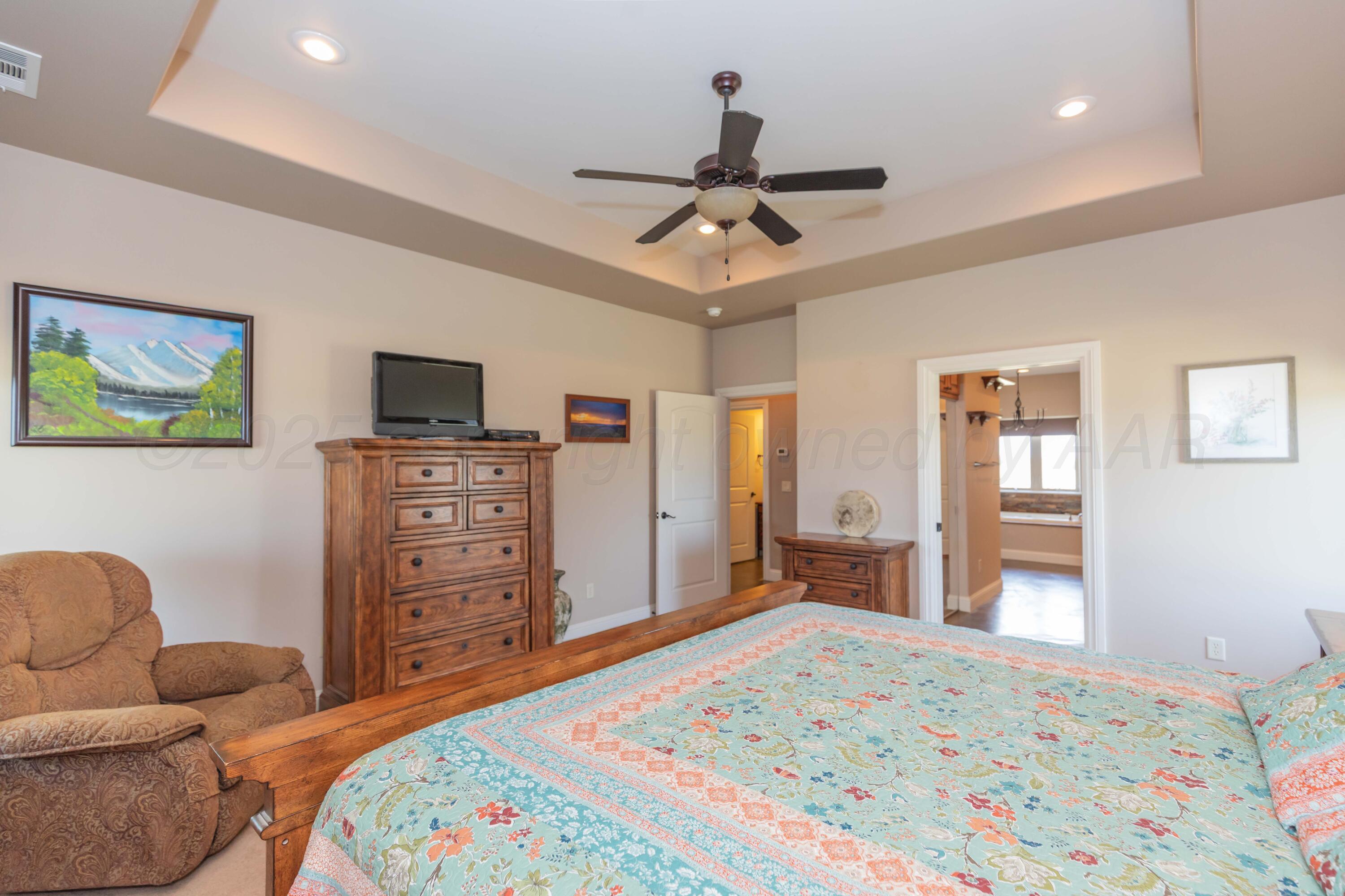 11400 Busan Way Canyon, TX 79015 - Photo 26 of 107 a bedroom with a bed a dresser and a flat screen tv