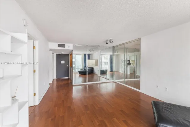 a hallway with wooden floor chandelier and windows