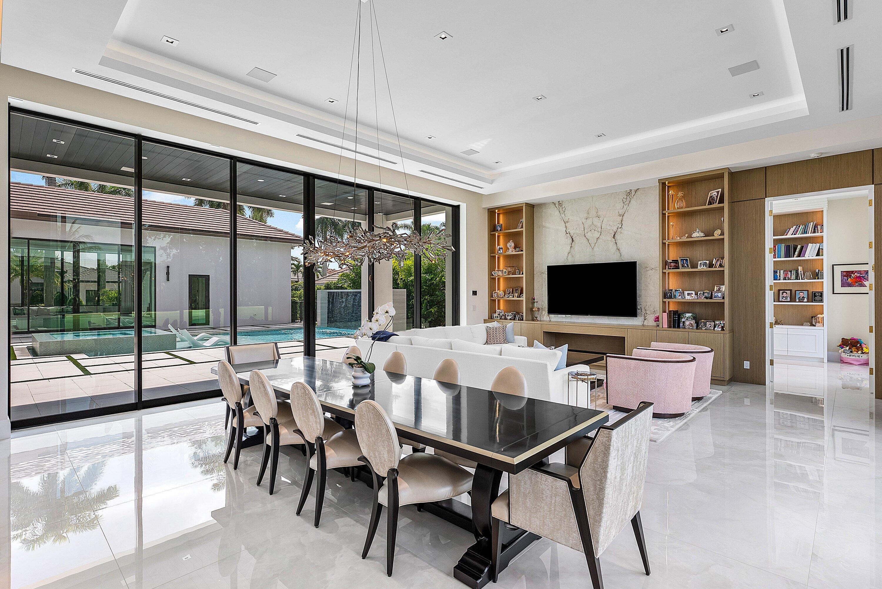 17615 Foxborough Lane Boca Raton, FL 33496 - Photo 19 of 120 a living room with furniture a flat screen tv and a floor to ceiling window