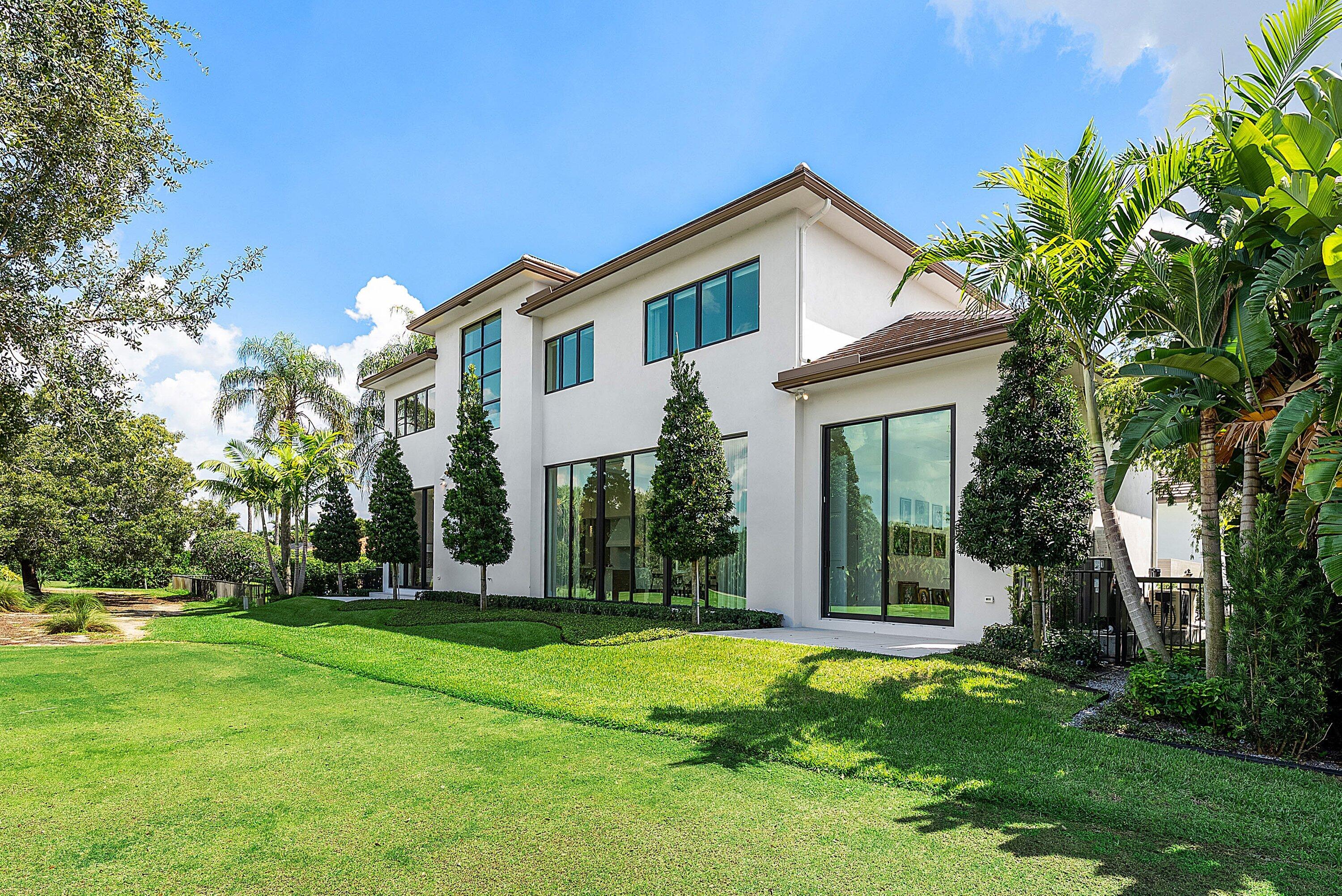 17615 Foxborough Lane Boca Raton, FL 33496 - Photo 56 of 120 a view of a white house with a big yard and potted plants and large trees