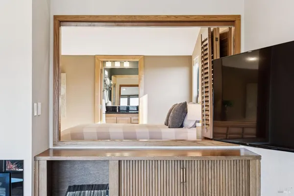 a living room with furniture large windows and wooden floor