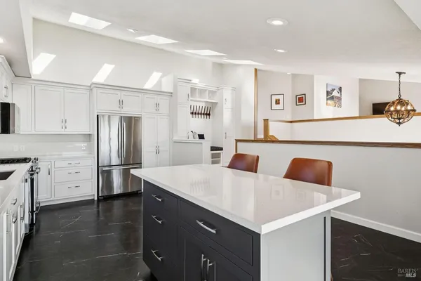 a kitchen with cabinets stainless steel appliances a sink and a window