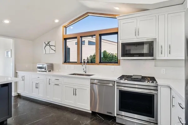 a dining hall with stainless steel appliances a table and chairs