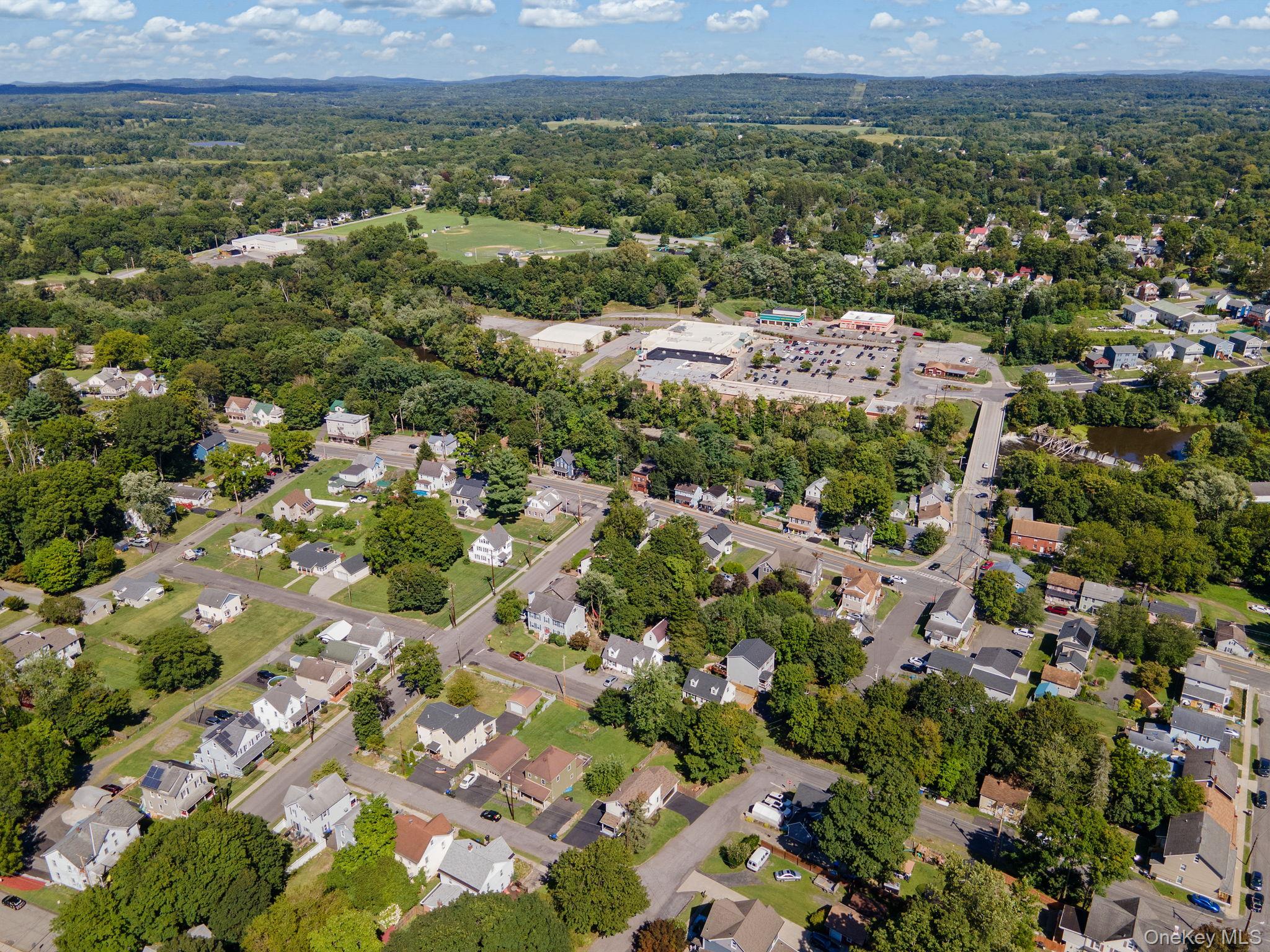 1 2nd Street Walden, NY 12586 - Photo 37 of 42 Aerial view of property and surrounding area with nearby suburban area and a tree filled landscape