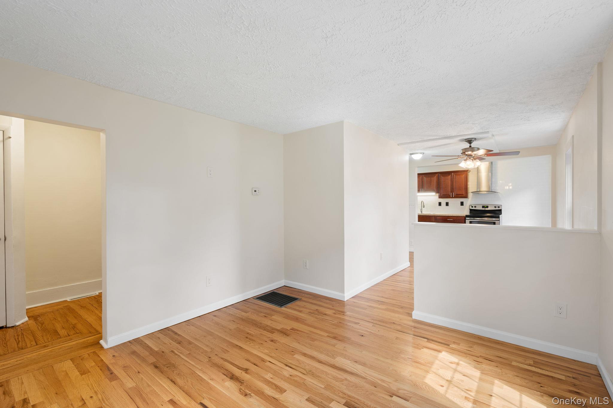 1 2nd Street Walden, NY 12586 - Photo 9 of 42 Unfurnished room featuring light wood finished floors, a textured ceiling, and ceiling fan