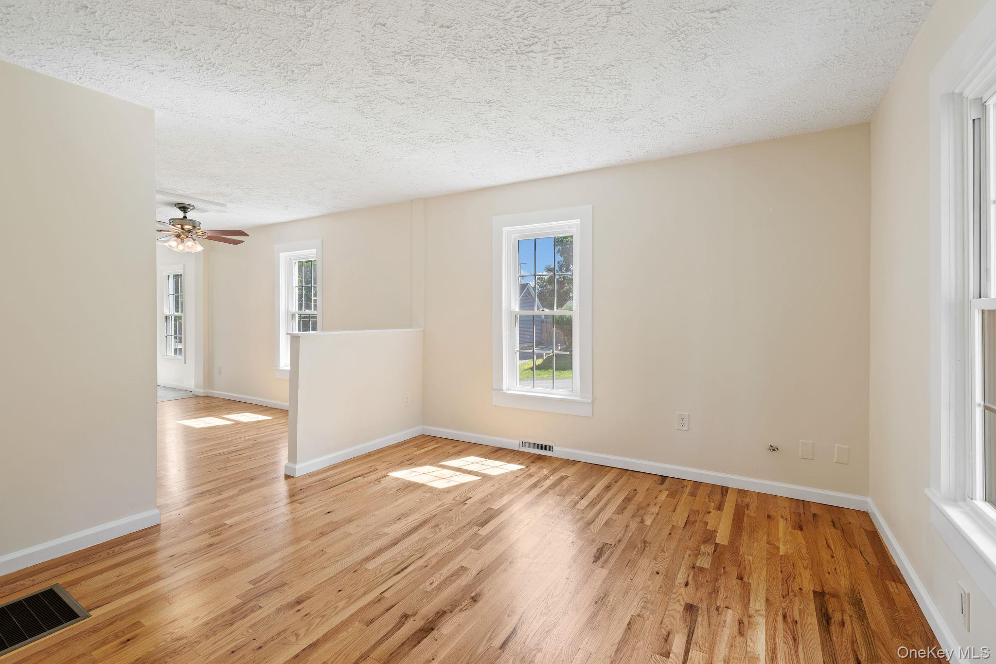 1 2nd Street Walden, NY 12586 - Photo 10 of 42 Unfurnished room with light wood-style flooring, a textured ceiling, and ceiling fan