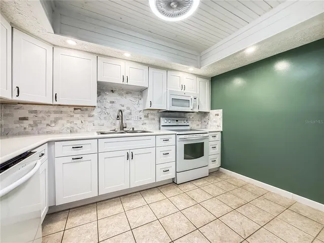 a kitchen with cabinets appliances and a sink