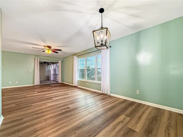 a view of empty room with wooden floor and window