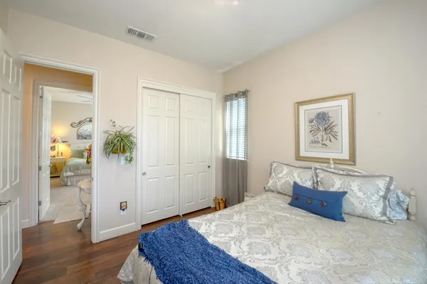 a bedroom with a large bed and wooden floor