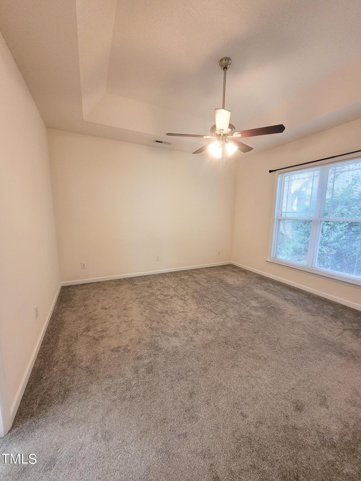 2349 Sapphire Valley Drive Raleigh, NC 27604 - Photo 23 of 46 an empty room with a chandelier fan and windows