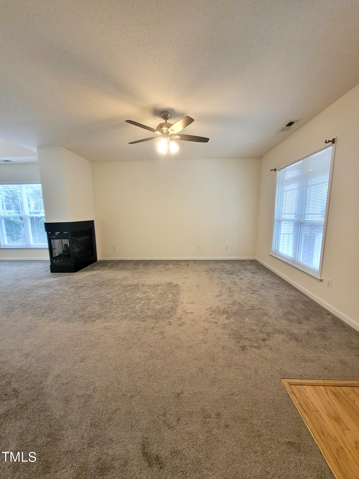 2349 Sapphire Valley Drive Raleigh, NC 27604 - Photo 7 of 46 an empty room with chandelier fan and windows