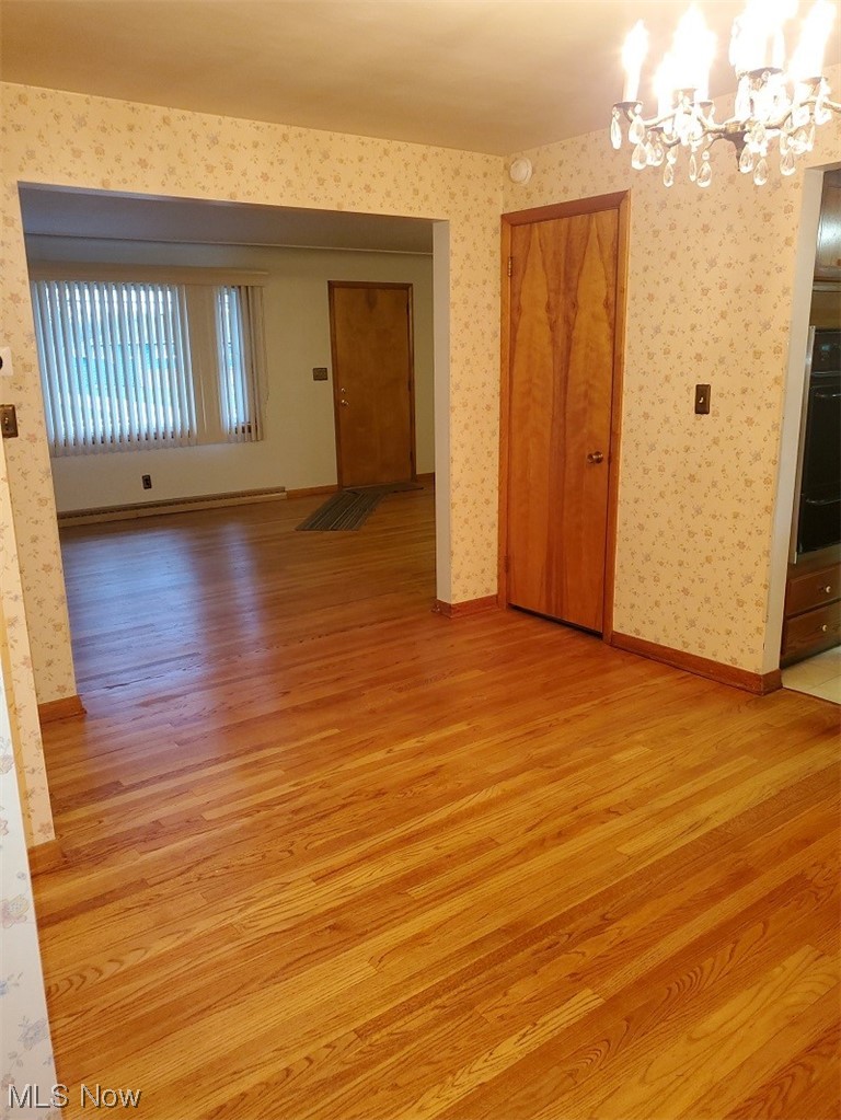 932 Pinecrest Road Girard, OH 44420 - Photo 9 of 25 Empty room featuring a chandelier and light wood-type flooring