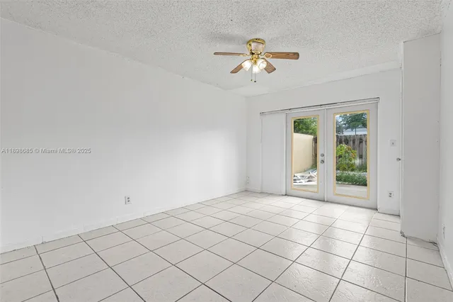 a view of an empty room with a chandelier fan