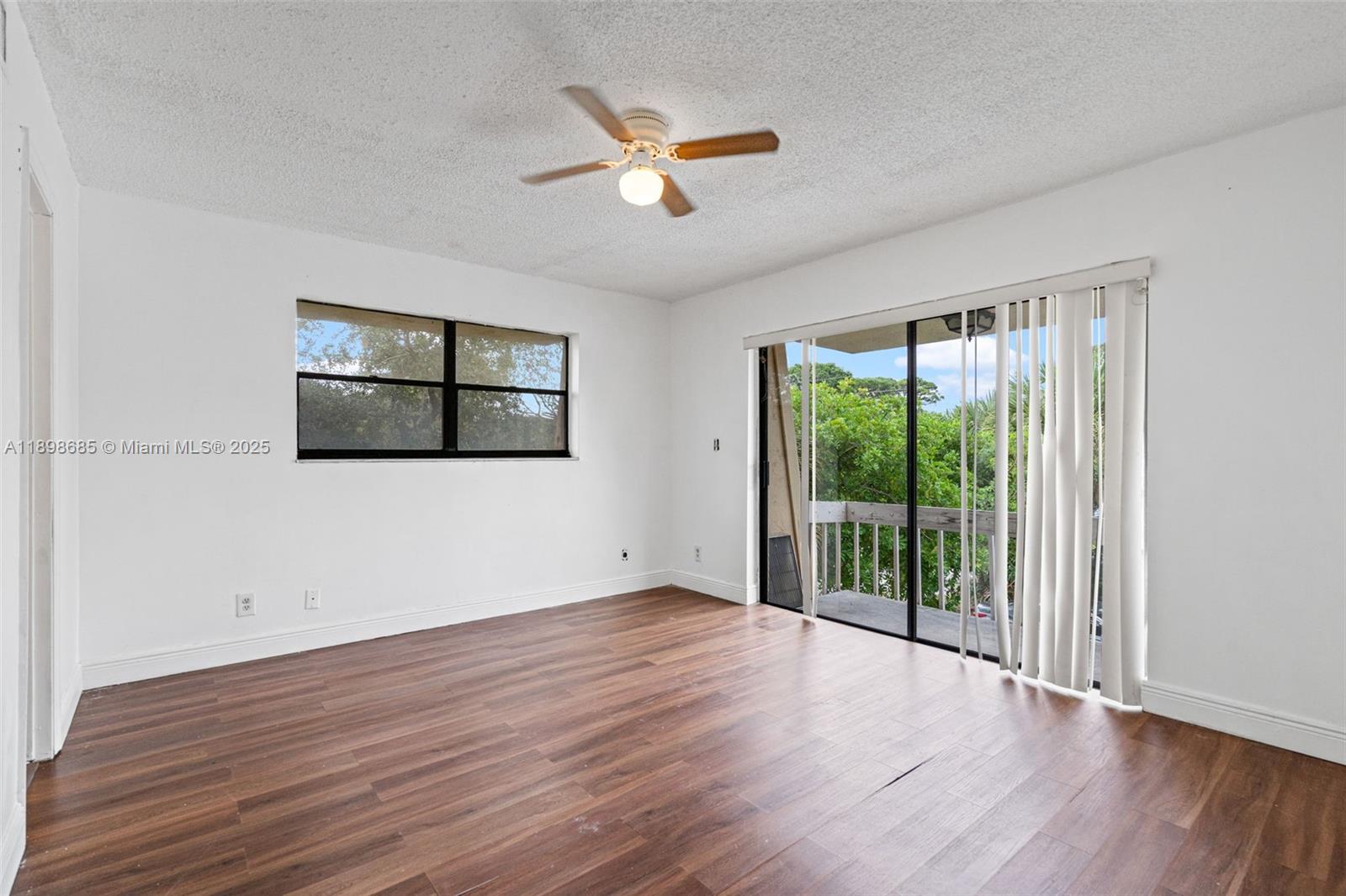 941 Southwest 20th Court Delray Beach, FL 33445 - Photo 18 of 46 a view of an empty room with wooden floor and a window