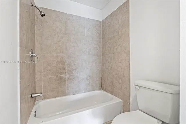 a white bath tub sitting next to a white toilet and sink