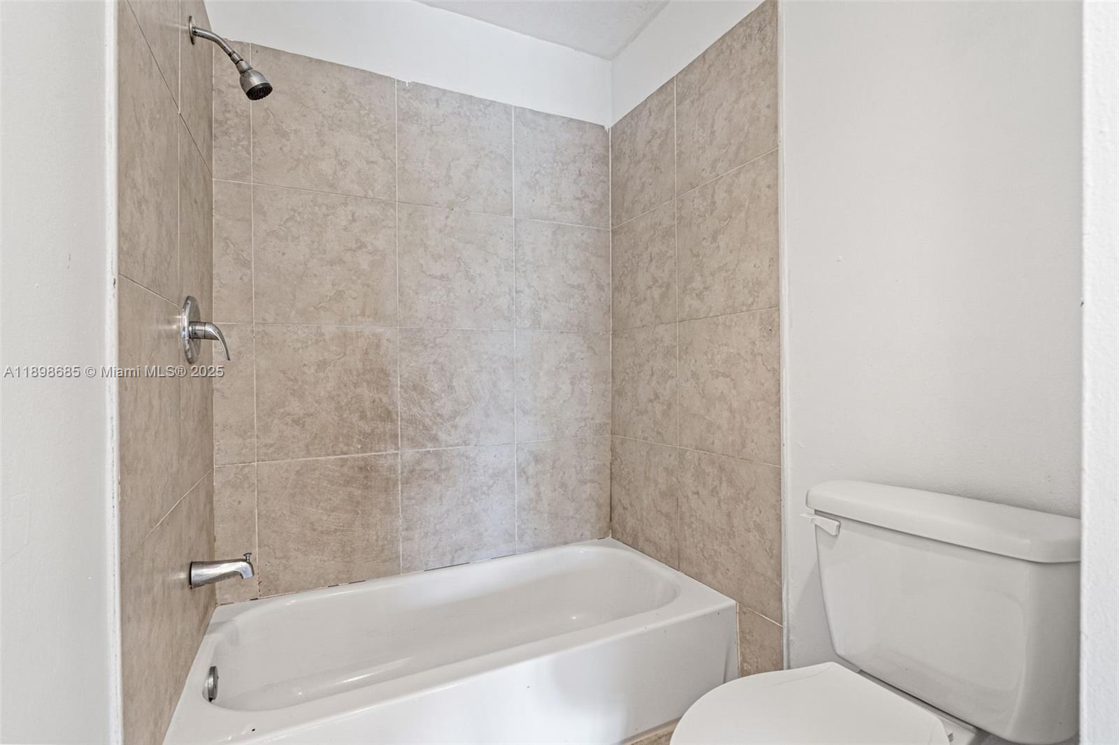 941 Southwest 20th Court Delray Beach, FL 33445 - Photo 22 of 46 a white bath tub sitting next to a white toilet and sink