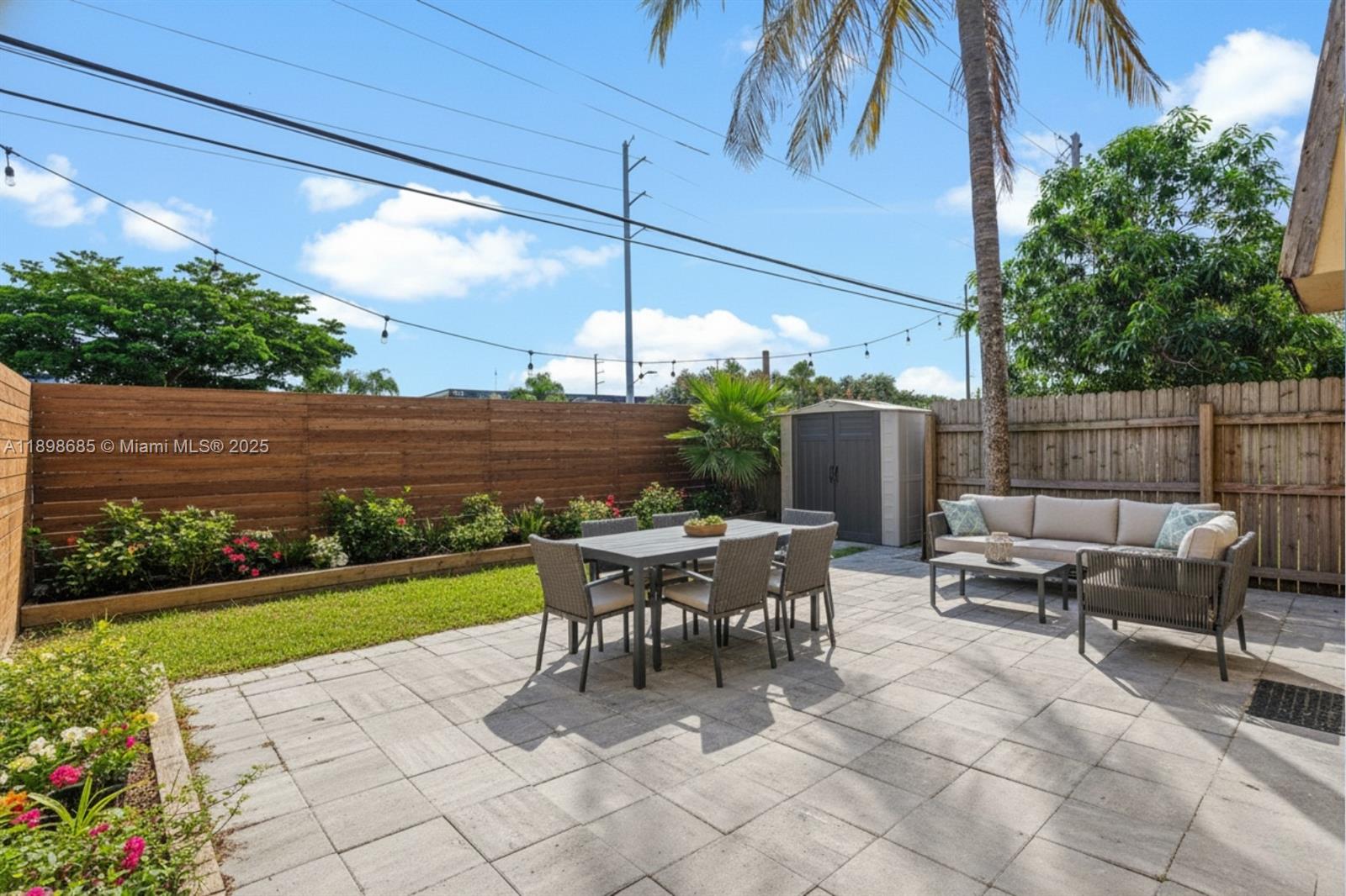 941 Southwest 20th Court Delray Beach, FL 33445 - Photo 35 of 46 a view of a patio with a dining table and chairs with wooden fence