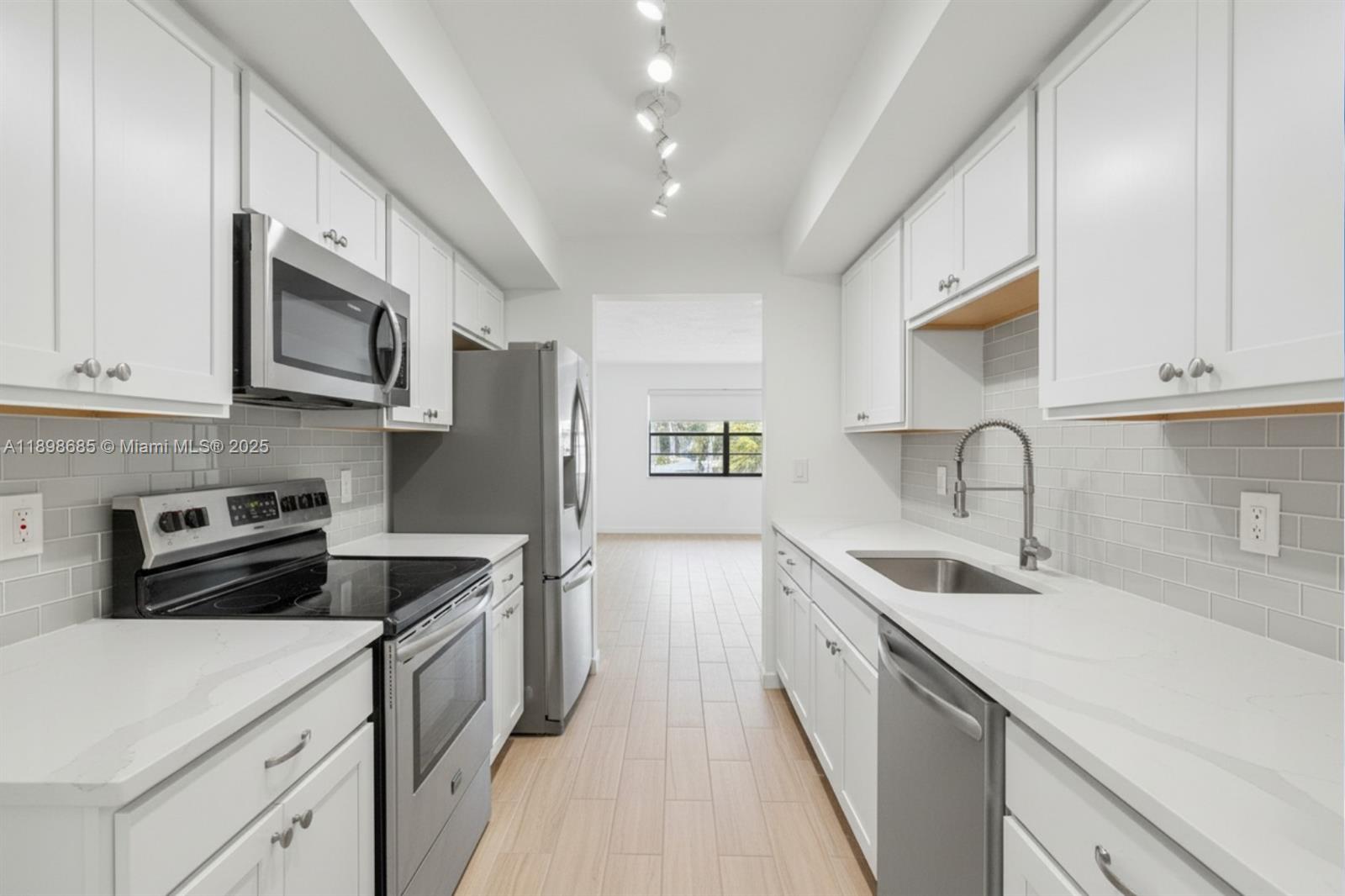 941 Southwest 20th Court Delray Beach, FL 33445 - Photo 10 of 46 a kitchen with stainless steel appliances granite countertop a sink stove and refrigerator