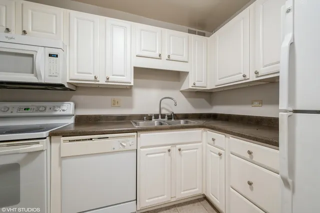a kitchen with white cabinets and white appliances