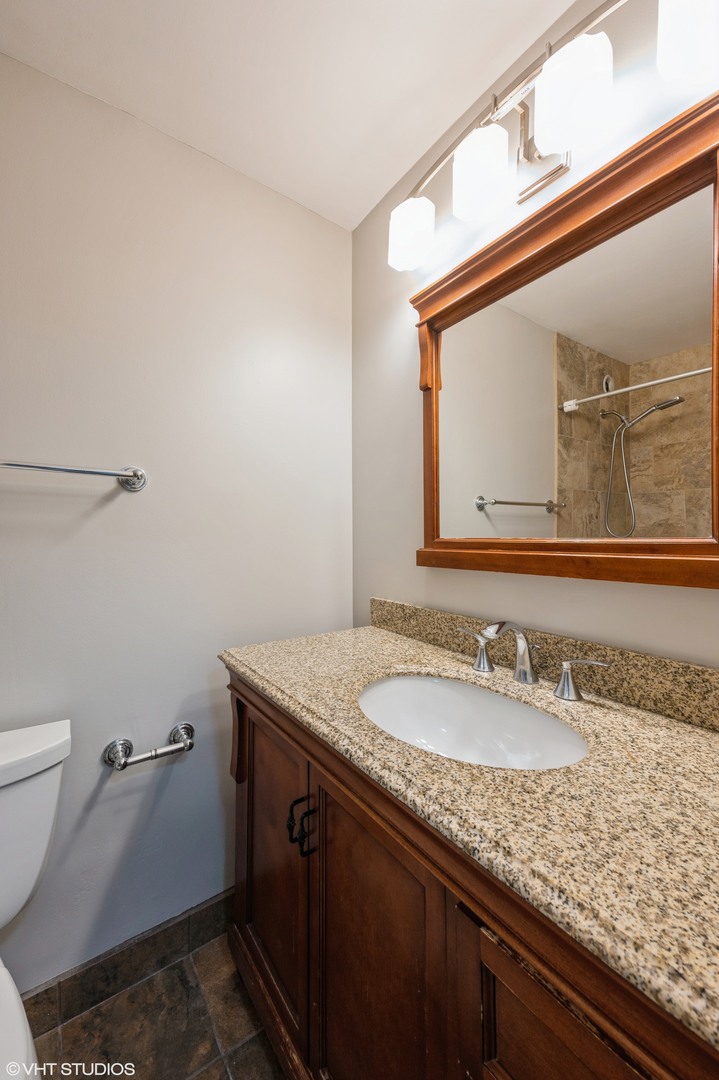 211 East Ohio Street, Unit 723 Chicago, IL 60611 - Photo 8 of 14 a bathroom with a granite countertop sink a toilet and a mirror