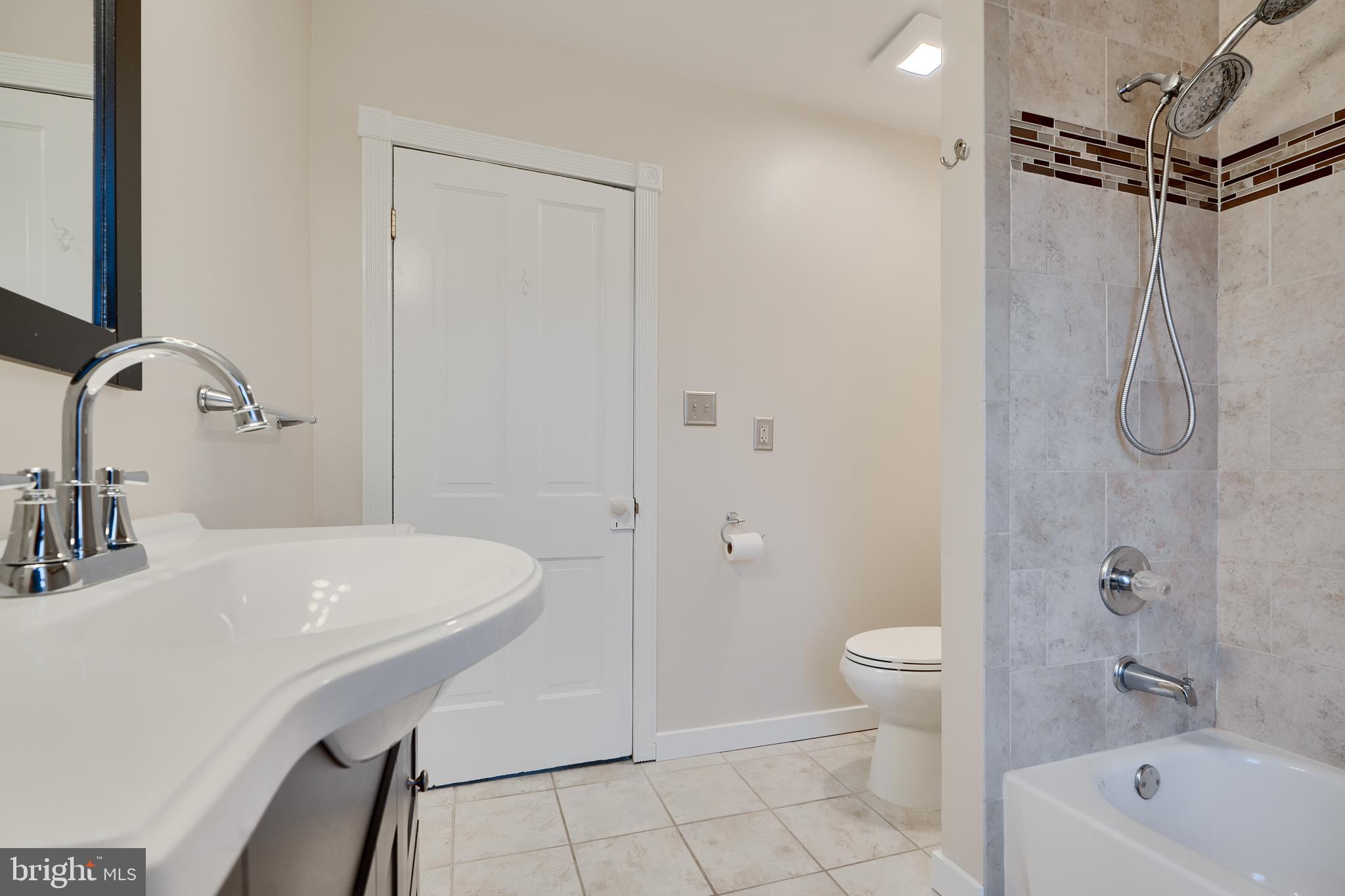 1817 Summit Avenue Baltimore, MD 21227 - Photo 18 of 28 a bathroom with a sink a toilet and shower