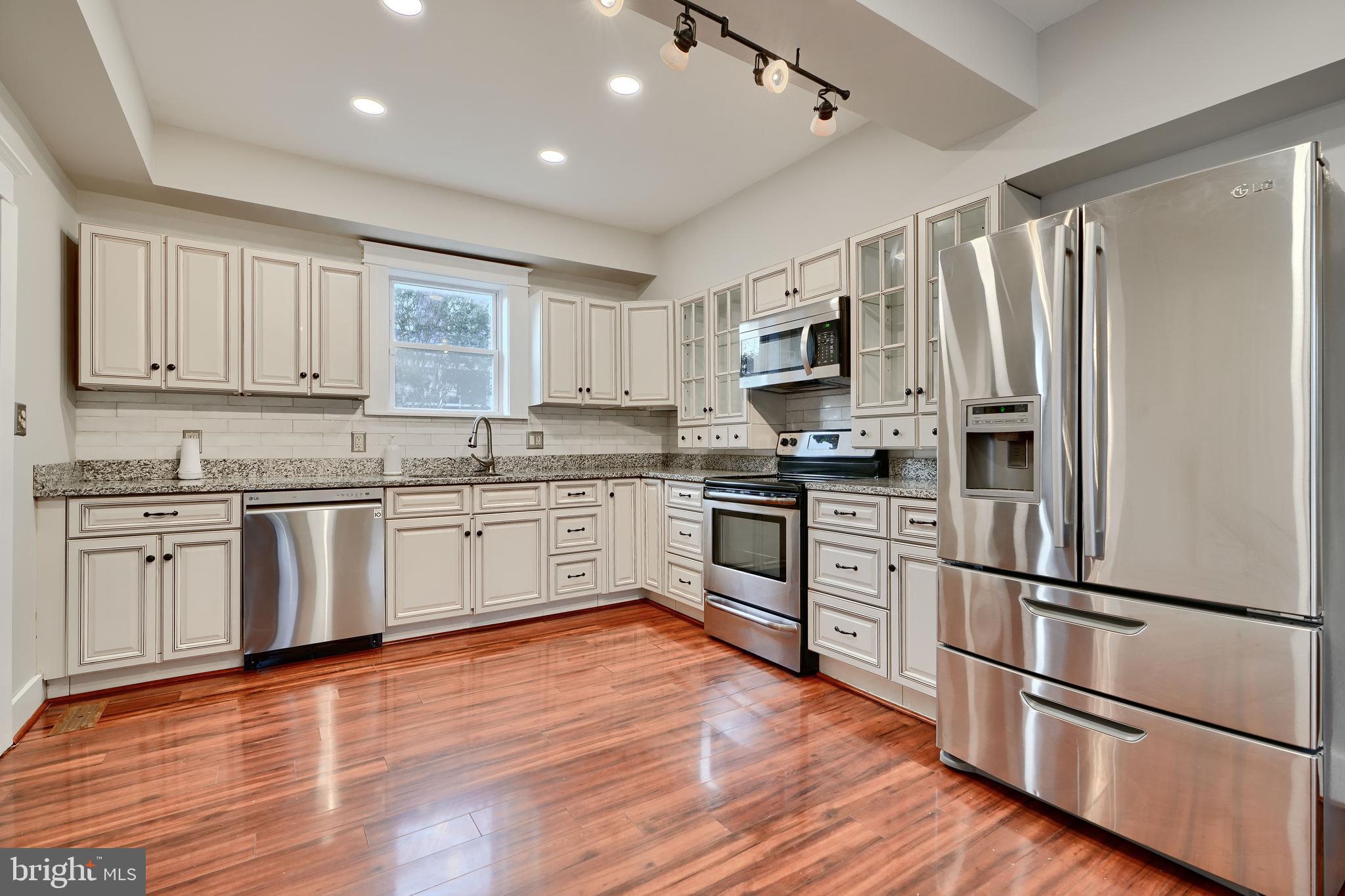 1817 Summit Avenue Baltimore, MD 21227 - Photo 2 of 28 a kitchen with stainless steel appliances granite countertop a refrigerator cabinets and wooden floor