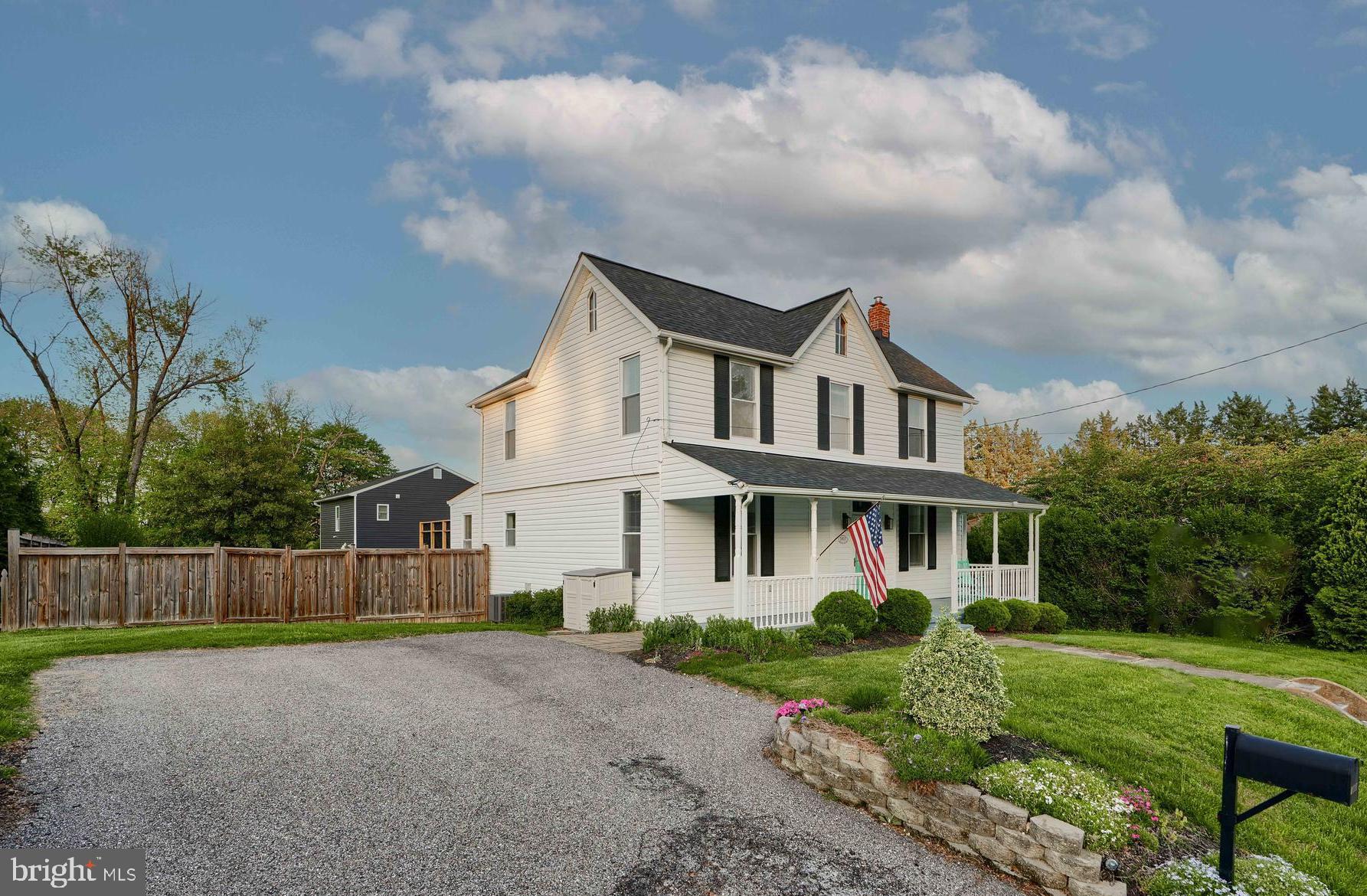 1817 Summit Avenue Baltimore, MD 21227 - Photo 27 of 28 a view of a white house next to a yard with big trees