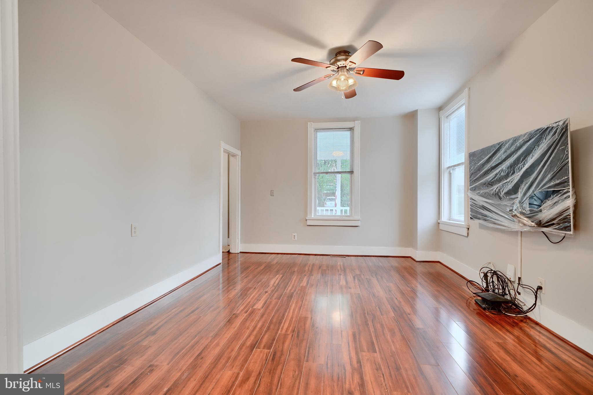 1817 Summit Avenue Baltimore, MD 21227 - Photo 5 of 28 a view of empty room with wooden floor and fan