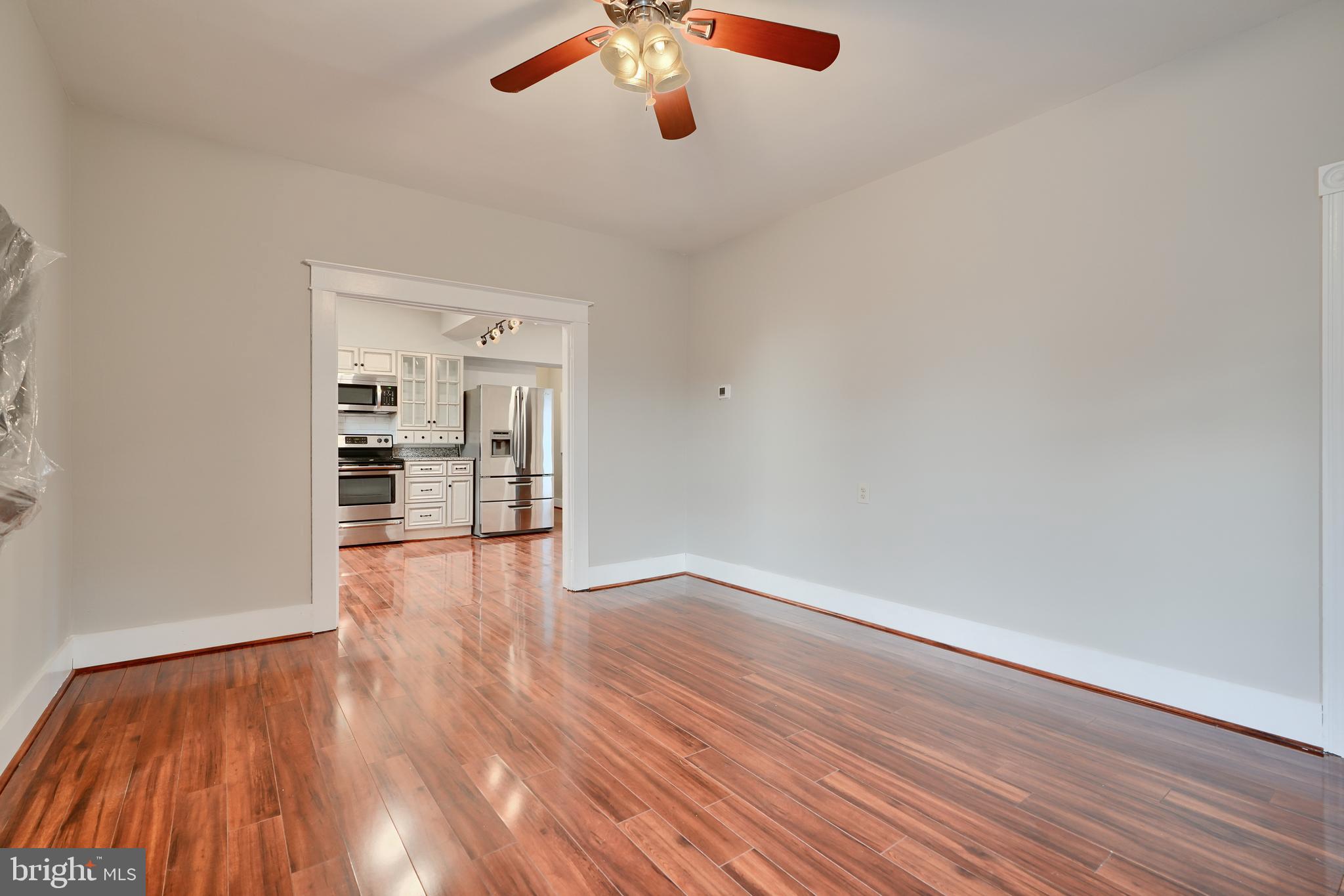 1817 Summit Avenue Baltimore, MD 21227 - Photo 6 of 28 a view of an empty room with wooden floor and a window
