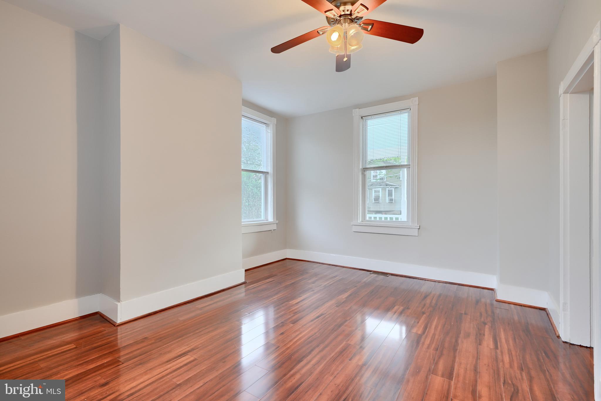 1817 Summit Avenue Baltimore, MD 21227 - Photo 8 of 28 a view of an empty room with wooden floor and a window