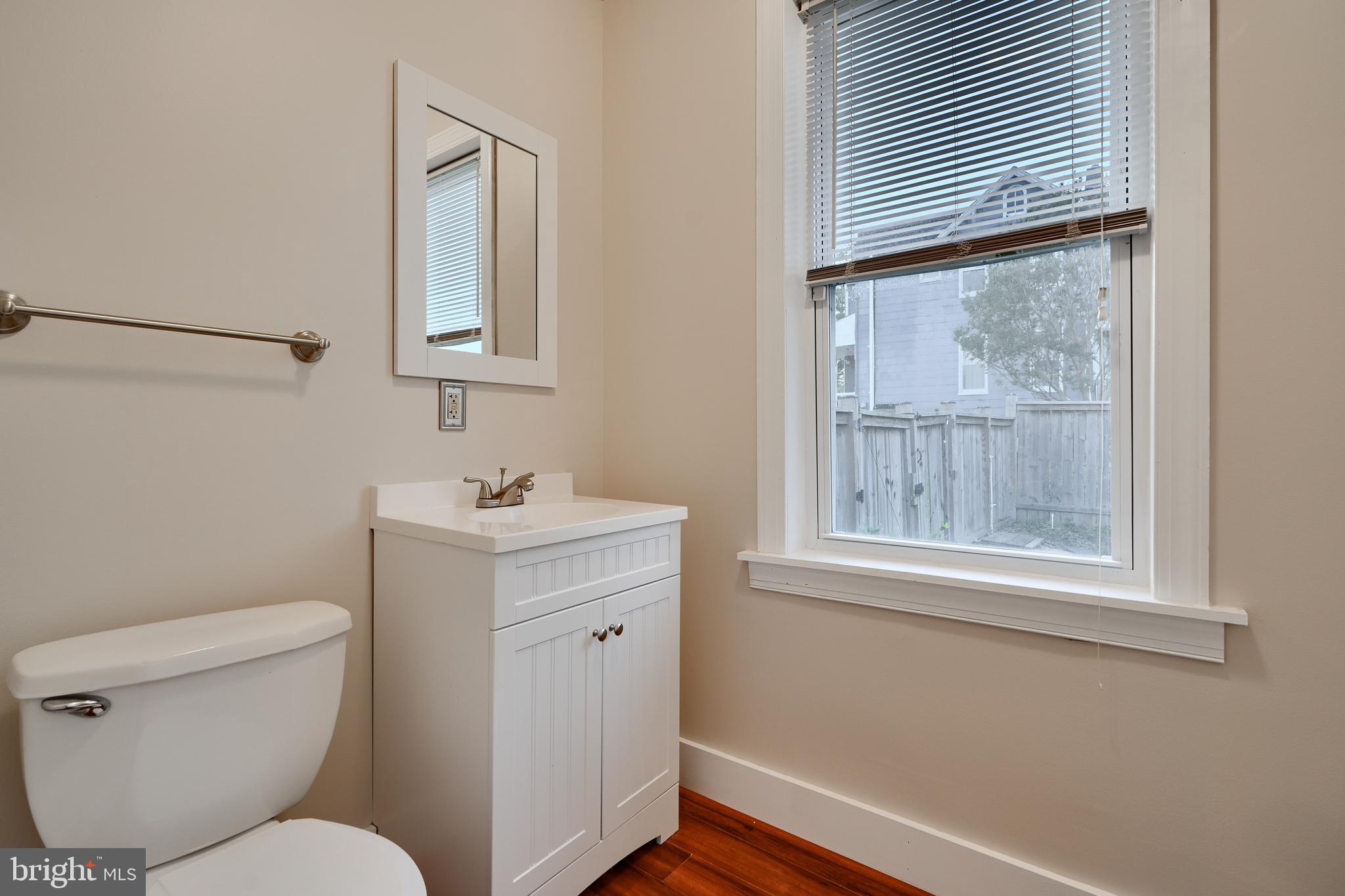 1817 Summit Avenue Baltimore, MD 21227 - Photo 9 of 28 a bathroom with a toilet a sink and a window