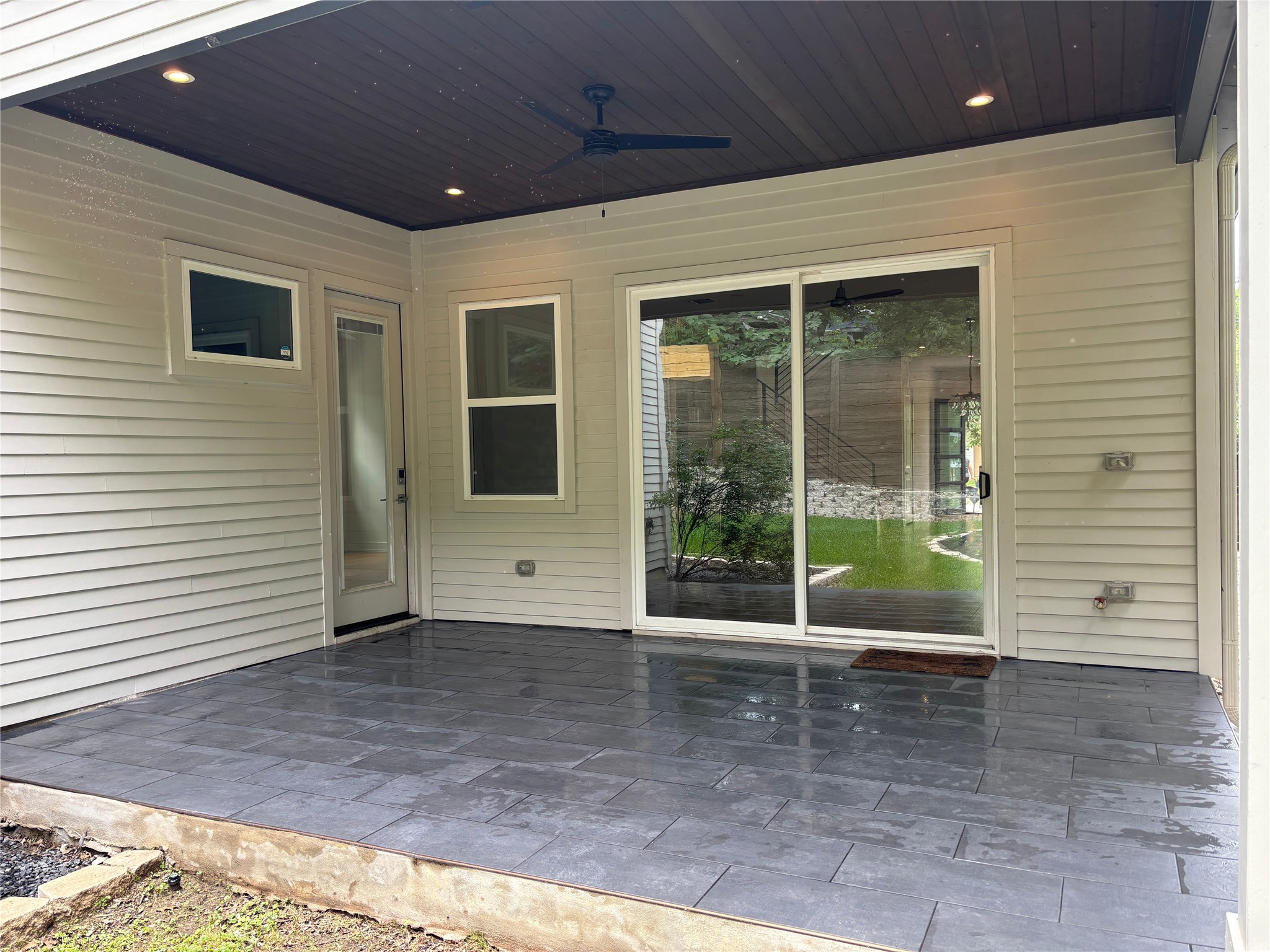 1719 Bunche Road Austin, TX 78721 - Photo 15 of 22 A well-lit, covered patio extends outdoor living space, featuring durable tiled flooring and easy access to the yard.