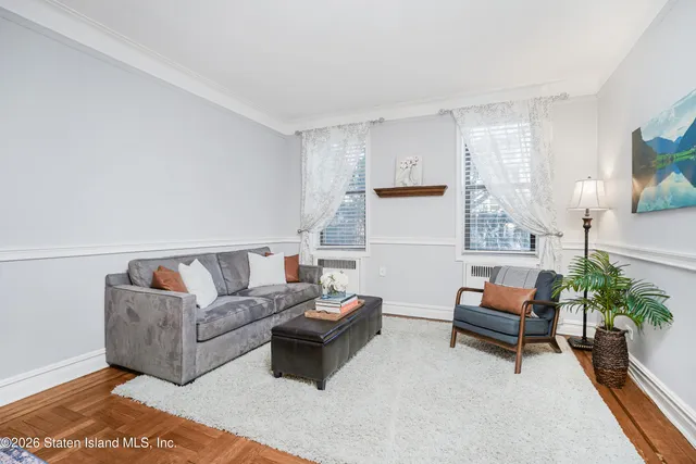a living room with furniture and a potted plant