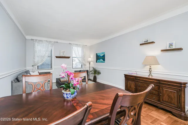 a view of a dining room with furniture a potted plant and wooden floor