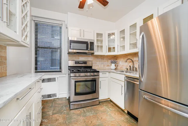 a kitchen with stainless steel appliances granite countertop a refrigerator a stove a sink and a microwave