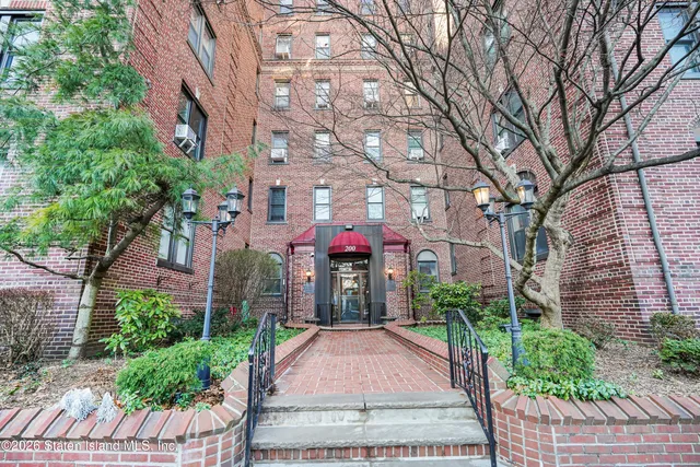 a front view of a multi story building with yard