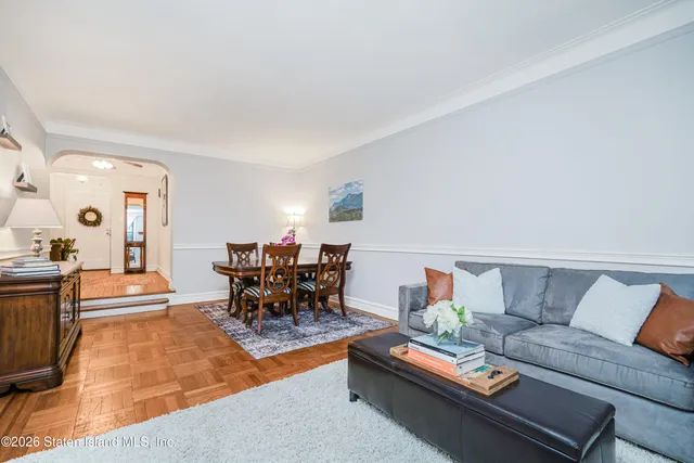 a living room with furniture and a dining table with potted plant